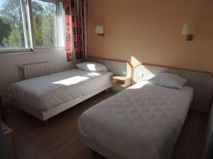 a hotel room with two beds and a window at Hôtel Le Sully La Roche Sur Yon in La Roche-sur-Yon