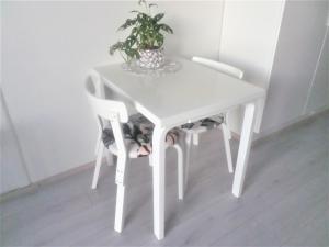 un tavolo bianco con due sedie e una pianta sopra di Compact high quality top floor studio in perfect location a Oulu Altre 5 foto