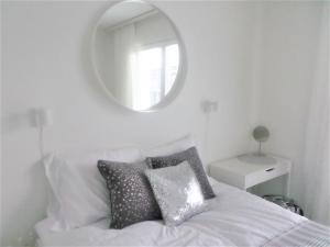 um quarto com uma cama branca e um espelho em Compact high quality top floor studio in perfect location em Oulu