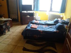 Schlafzimmer mit einem Bett mit blauer Decke in der Unterkunft Lillafüred Kapuja Hotel in Miskolc
