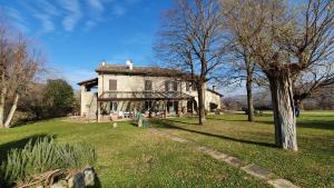 an old house in a field with trees and grass at Agriturismo Virano19 in Castrocaro Terme