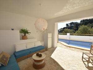 - un salon avec un canapé bleu et une piscine dans l'établissement Belvilla by OYO Casa La Vida, à Benissa