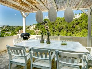 - une table et des chaises blanches sur la terrasse dans l'établissement Belvilla by OYO Casa La Vida, à Benissa