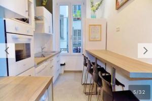 a kitchen with white cabinets and a counter with chairs at GARIBALDI chambre PRIVEE pour voyageurs CALMES exiger TRAM Ligne1 Palais des expositions au pied de l'immeuble in Nice