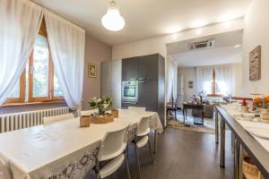 una cucina e una sala da pranzo con tavoli e sedie bianchi di B&b Igea 50 a Modena