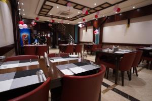 a dining room with tables and chairs in a restaurant at Hotel Varanasi Heritage in Varanasi