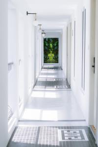 um corredor vazio com paredes brancas e pisos brancos em Indie Hotel Kuala Lumpur em Kuala Lumpur