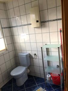 Un baño con inodoro y una pared de azulejos. en Bluhm OG, en Wangerland