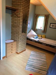 1 dormitorio con 1 cama y chimenea de ladrillo en Bluhm OG, en Wangerland