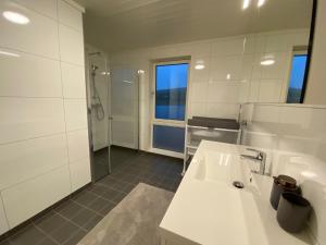 y baño blanco con lavabo y ducha. en Rorbu by Nappstraumen, Lofoten en Gravdal