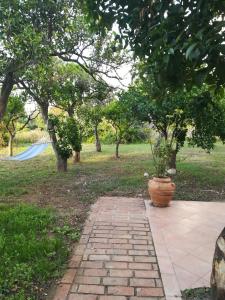 Una pasarela de ladrillo con una maceta en un parque en Case vacanza vicino al mare, en Parghelia