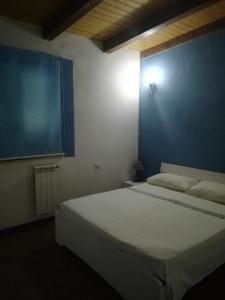 1 dormitorio con 1 cama grande y pared azul en Case vacanza vicino al mare, en Parghelia