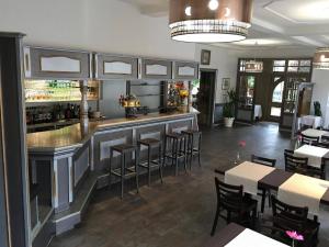 a restaurant with a bar and tables and chairs at Hôtel Restaurant Le Bristol in Niederbronn-les-Bains