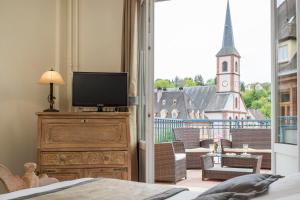 - une chambre avec une grande fenêtre donnant sur une église dans l'établissement Hôtel Restaurant Le Bristol, à Niederbronn-les-Bains