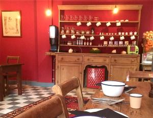 a dining room with a table and a red wall at The Black Hole in Winchester