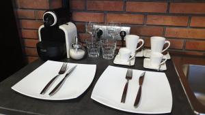 a white table topped with plates and utensils at Orange Hotel in Yartsevo