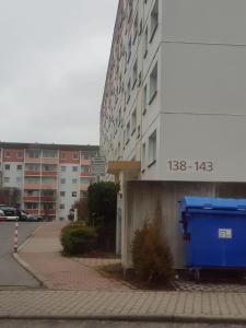 un contenedor azul sentado en un lado de un edificio en Ferienwohnung 143 en Annaberg-Buchholz