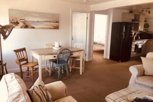 a kitchen and living room with a table and chairs at Bay House Lundy Port Isaac Apartment with Sea Views in Port Isaac