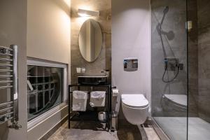 ein Badezimmer mit Toilette, Waschbecken und Spiegel in der Unterkunft ArtLoft Garni Hotel in Niš