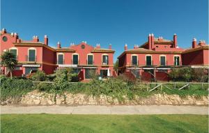 een groot rood huis op een grasveld bij Olhando um Campo de Golf in Islantilla