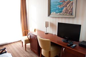 a hotel room with a desk with a television at Hotel Encian in Rajecké Teplice