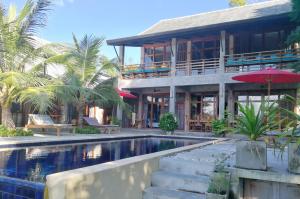 ein Haus mit einem Pool vor einem Gebäude in der Unterkunft Ping Pool Villa 1 in Mae Rim