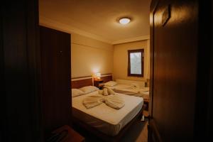 una camera con due letti e asciugamani di ERİSH APART HOTEL a Kerpe