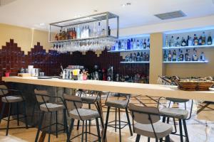 un bar con sgabelli in una stanza con bottiglie di Athens Starlight Hotel ad Atene