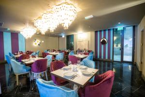 une salle à manger avec des tables et des chaises ainsi qu'un lustre dans l'établissement Brosse Garden, à Tbilissi