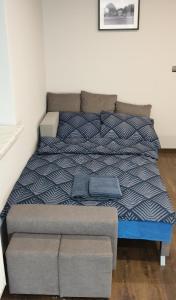 a bed with a blue and white comforter in a room at Wadowice Apartamenty Nad Skawą in Wadowice