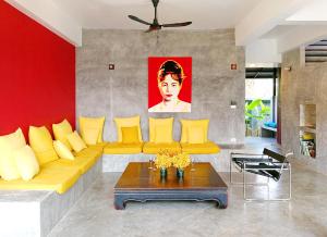 a living room with a yellow couch and a table at Ping Pool Villa 2 in Mae Rim