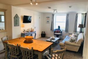 a living room with a table and a couch at Bay House Lobber Port Isaac Apartment with Sea Views in Port Isaac