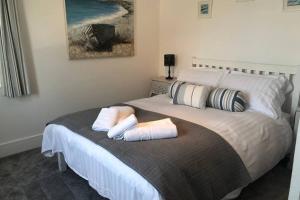 a bedroom with a bed with two towels on it at Bay House Lobber Port Isaac Apartment with Sea Views in Port Isaac