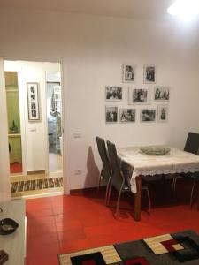 uma sala de jantar com mesa e cadeiras e quadros na parede em Marina House em Olbia