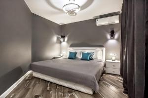 a bedroom with a large bed with blue pillows at Grey Cardinal Apartment SUTKI LIFE in Tolyatti