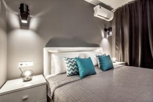 a bedroom with a bed with two blue pillows at Grey Cardinal Apartment SUTKI LIFE in Tolyatti