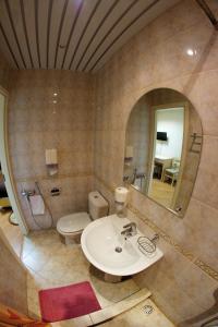 La salle de bains est pourvue d'un lavabo, de toilettes et d'un miroir. dans l'établissement Hotel na Okskoy, à Moscou