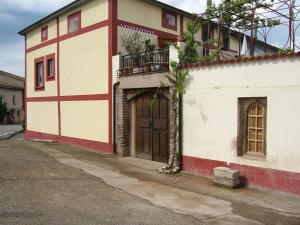 a red and white building with a door and a balcony at Casa Victoria in Cirueña