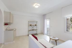 a white living room with a couch and a table at Apartment with a sea view and swimming pool, in the area of Koundouros in Koundouros