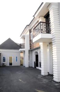 een wit huis met een balkon en een oprit bij JAYBRITT LUXURY APARTMENT in Ibadan