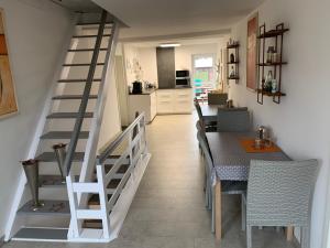 a dining room and kitchen with a staircase and a table at Das kleine Schwarze in Parsau