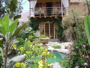 a garden with a pond in front of a house at Villa Celestial in Nieve Nieve