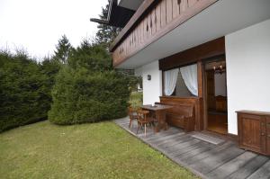 une terrasse avec une table et des chaises à côté d'une maison dans l'établissement Punta Nera: appartamento con giardino e WIFI, à Zuel