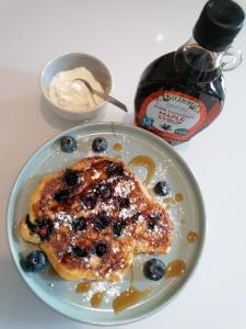 a plate of blueberry pancakes with syrup and a bottle of syrup at No 12 B&B in Dungarvan