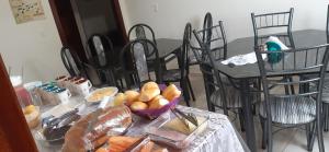 een tafel met stoelen en een tafel met eten erop bij Pousada Rio Novo Jalapão in Mateiros