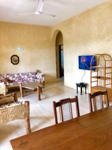 a living room with a couch and a table and chairs at Flametree Beach Homes in Diani Beach