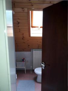a bathroom with a toilet and a window at Apartments Rozi in Bovec