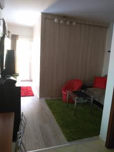 sala de estar con sofá rojo y alfombra verde en Apartmán Mery, en Podhájska