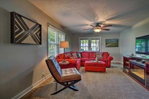 a living room with a red couch and a ceiling fan at Cute Emporia House - Mins to Downtown and ESU! in Emporia