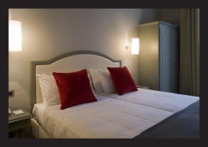 um quarto com uma cama com duas almofadas vermelhas em Hotel Rosso23 - WTB Hotels em Florença